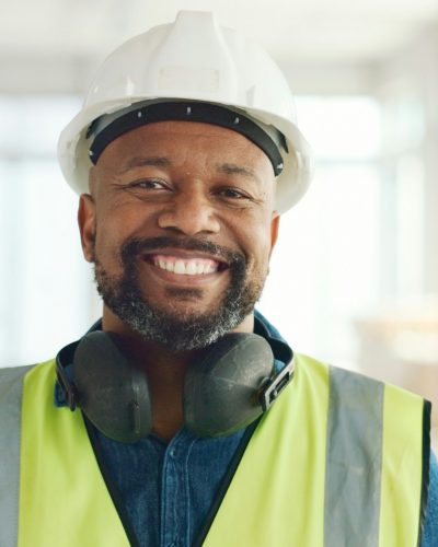 Construction, building and construction worker, man and smile in portrait, employee at construction